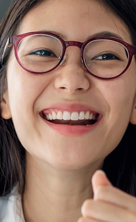 Woman with glasses smiling after dental services